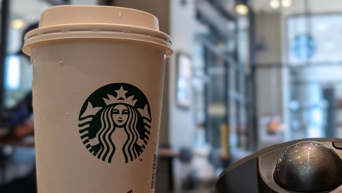 スタバのロゴが入った紙コップとカフェの背景